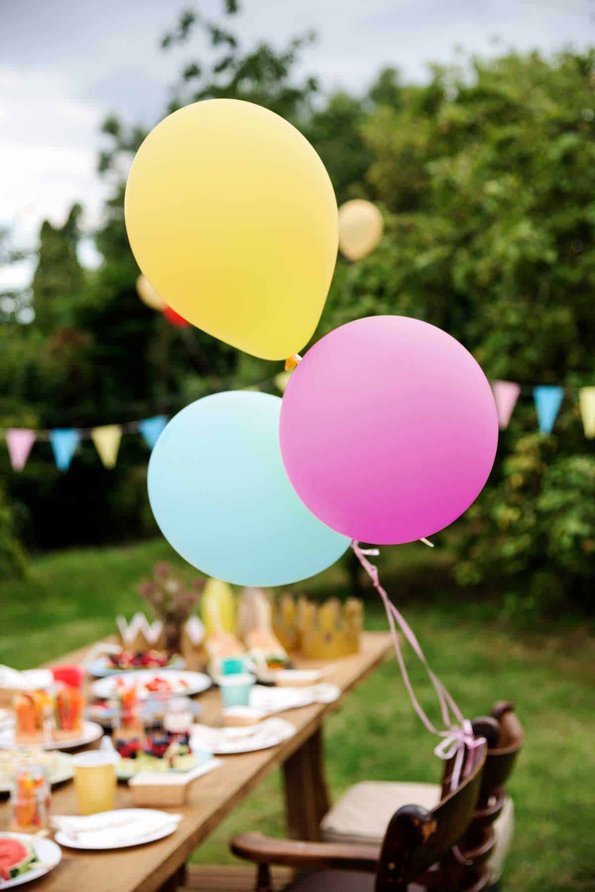Colourful balloons at  garden birthday picnic party. 