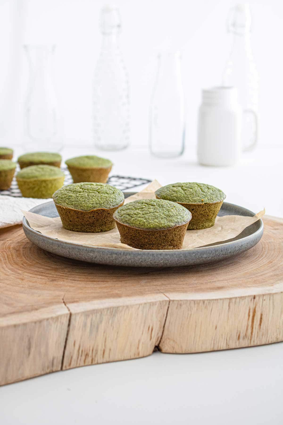Green spinach and banana muffins on a wooden plate.