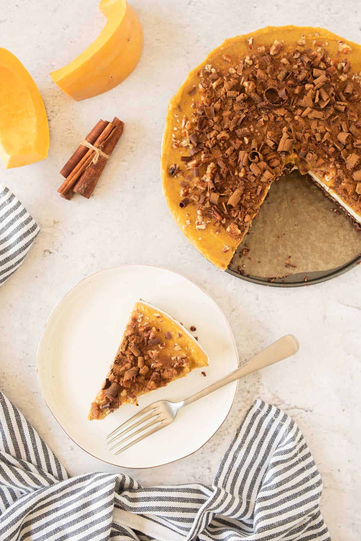 A pumpkin pie with a slice taken out of it.