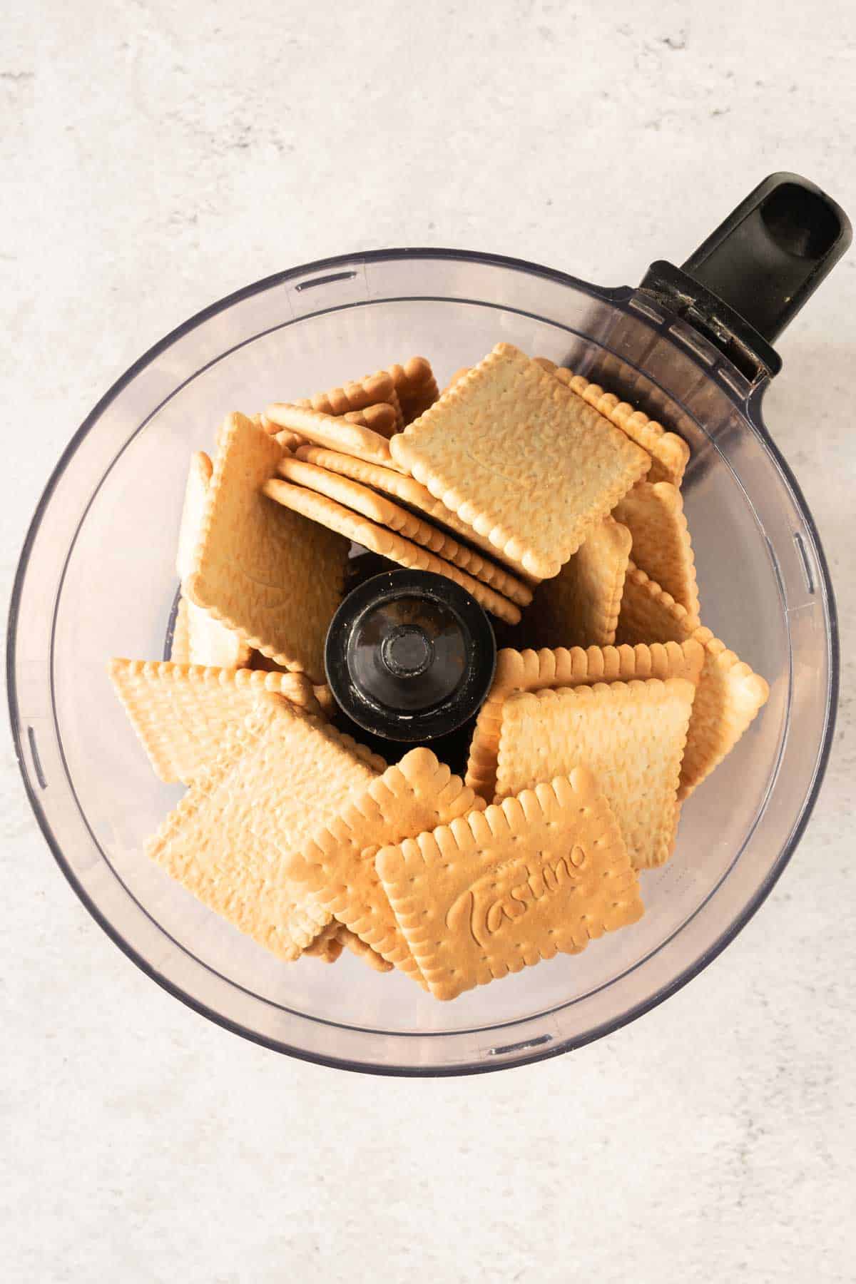 Biscuits in a food processor on a white background.