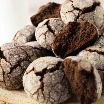 Chocolate crinkle cookies on a wooden plate.