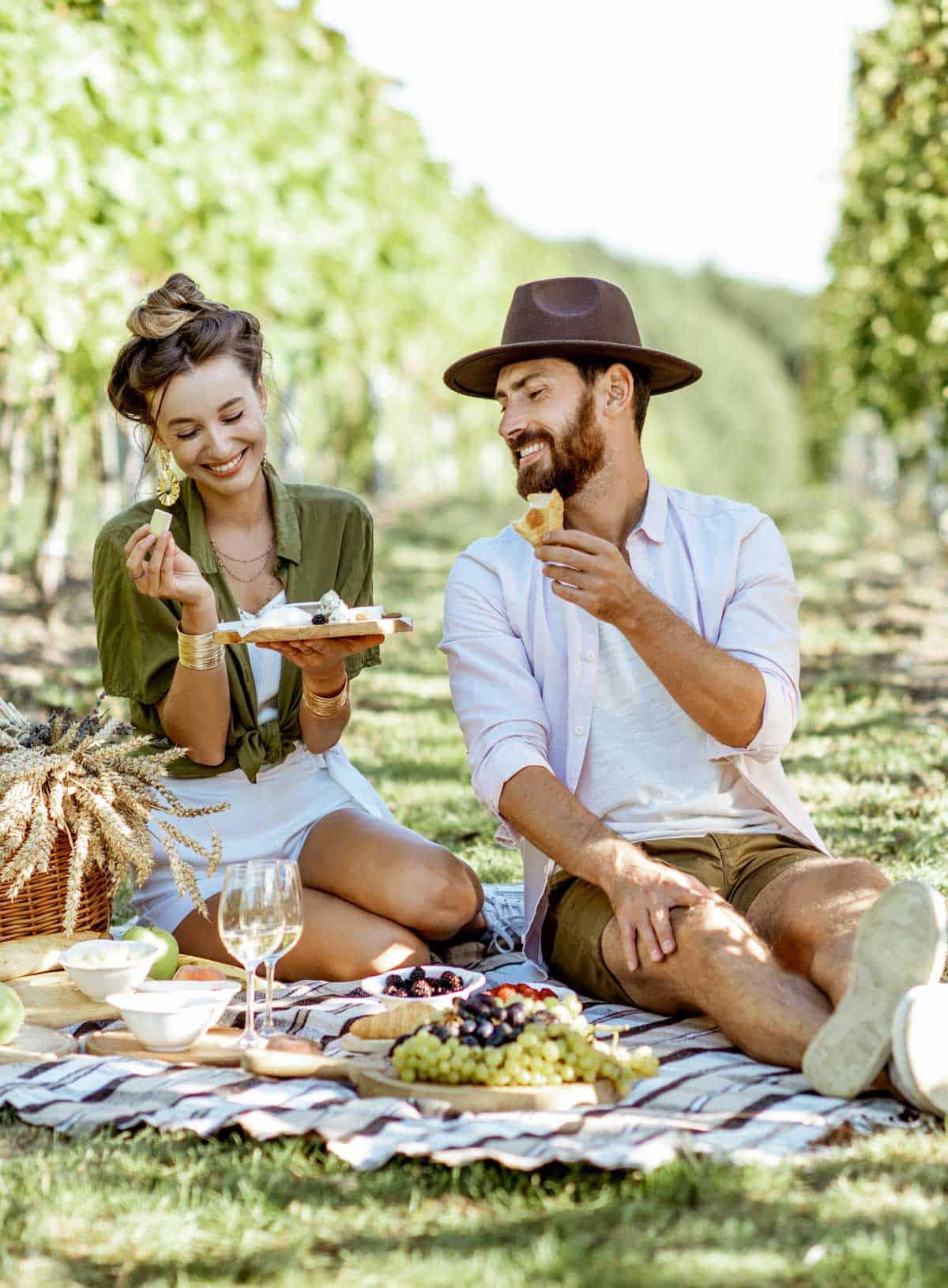Young couple having a picnic in a vineyard.