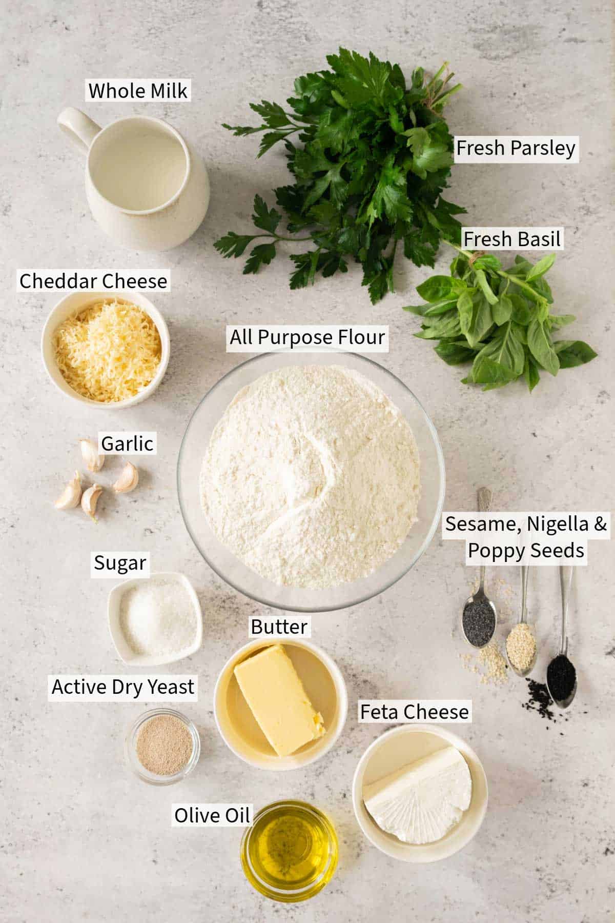 The ingredients for basil and feta cheese bread are shown on a white background.