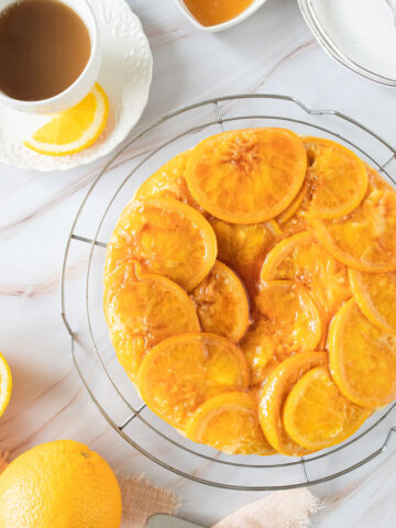 An orange upside down cake and a cup of coffee.