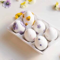 6 eggs decorated with dainty pressed flowers.