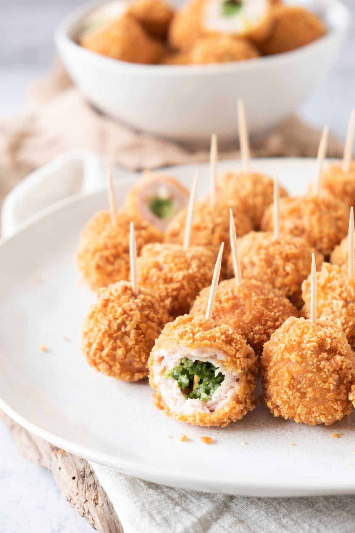 Fried chicken bites on a plate with toothpicks.