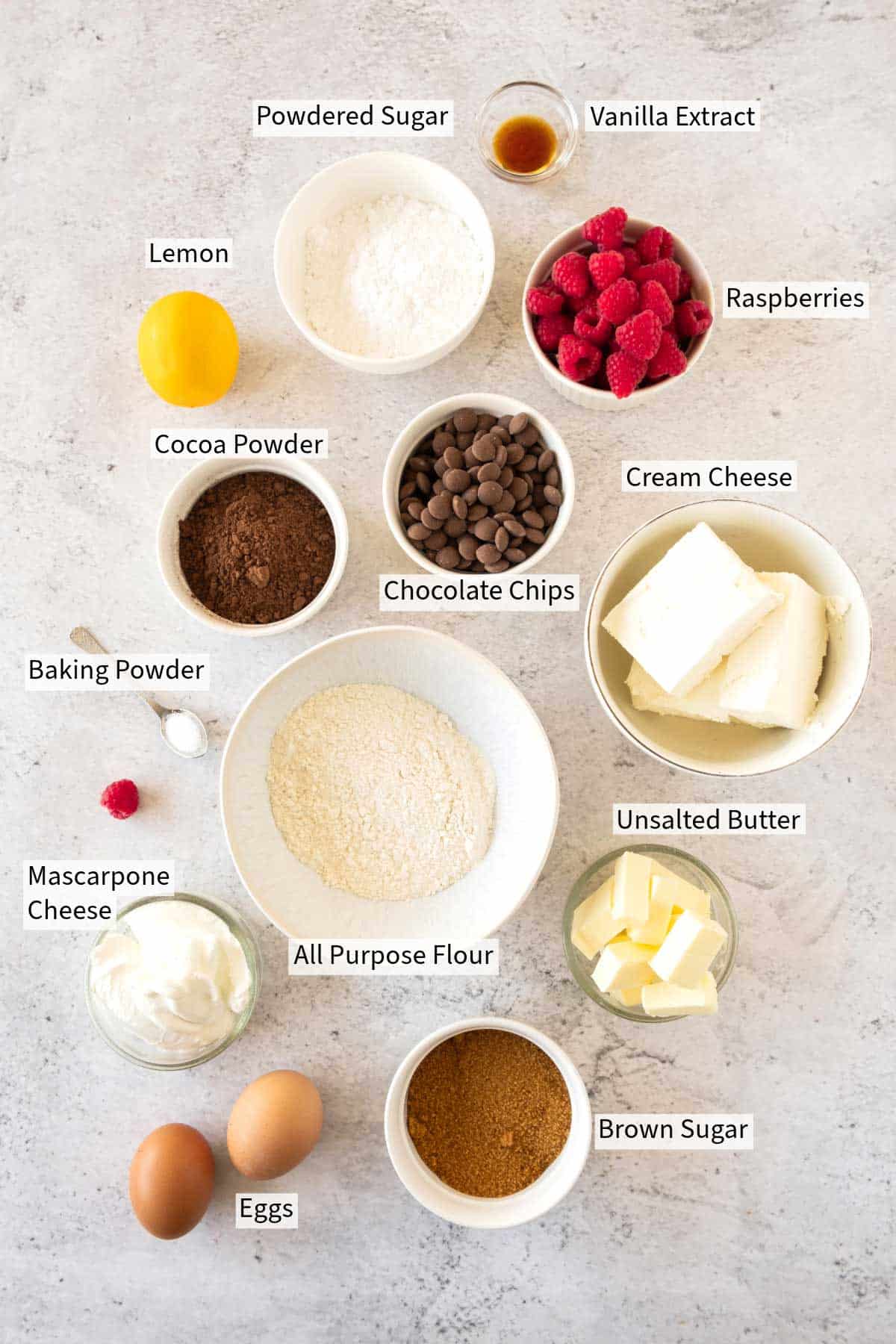 Ingredients for raspberry Cheesecake Brownies neatly arranged on a white surface, labeled with their names.