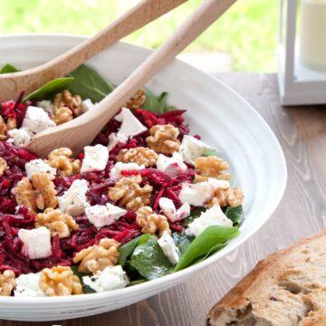 A fresh beetroot and goat cheese salad with walnuts, served with crusty bread.