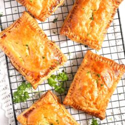 Golden brown pastries on a cooling rack garnished with parsley.