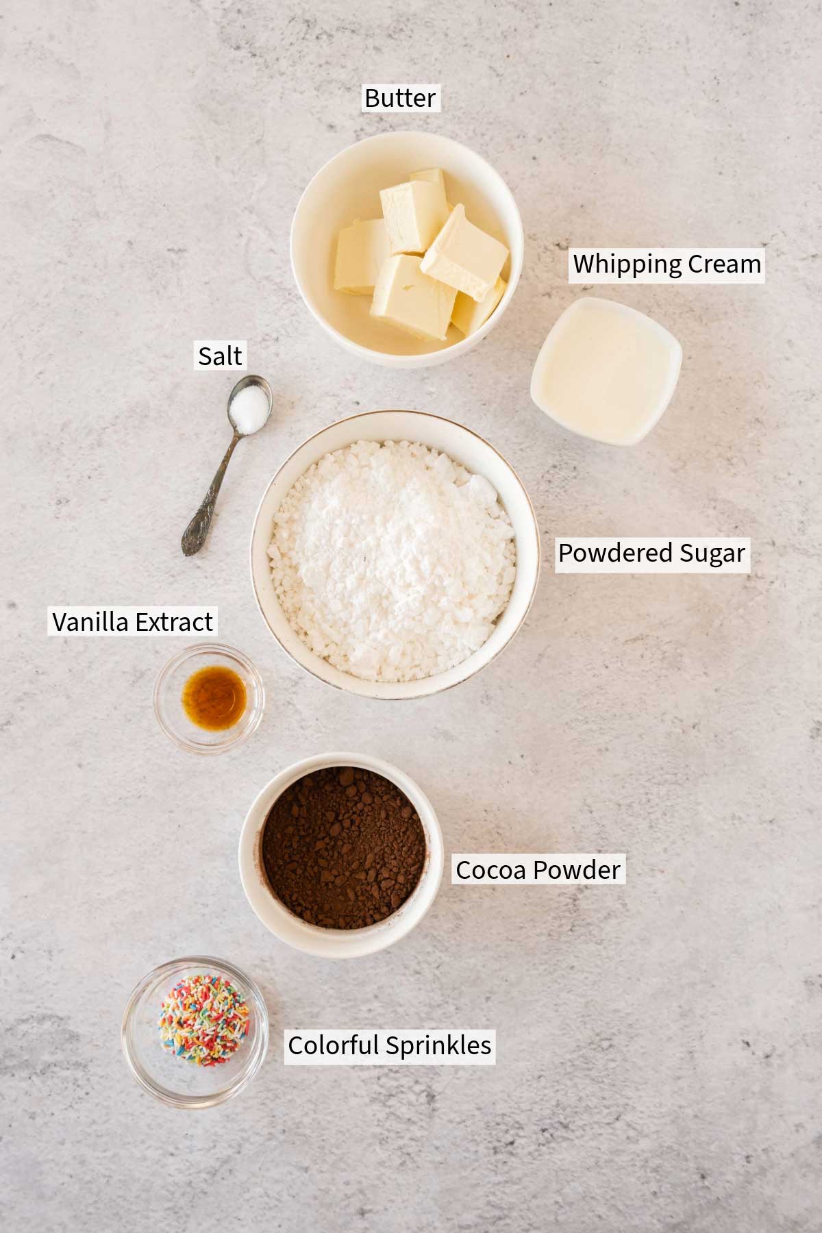 Ingredients for chocolate buttercream frosting on a kitchen counter, labeled individually.