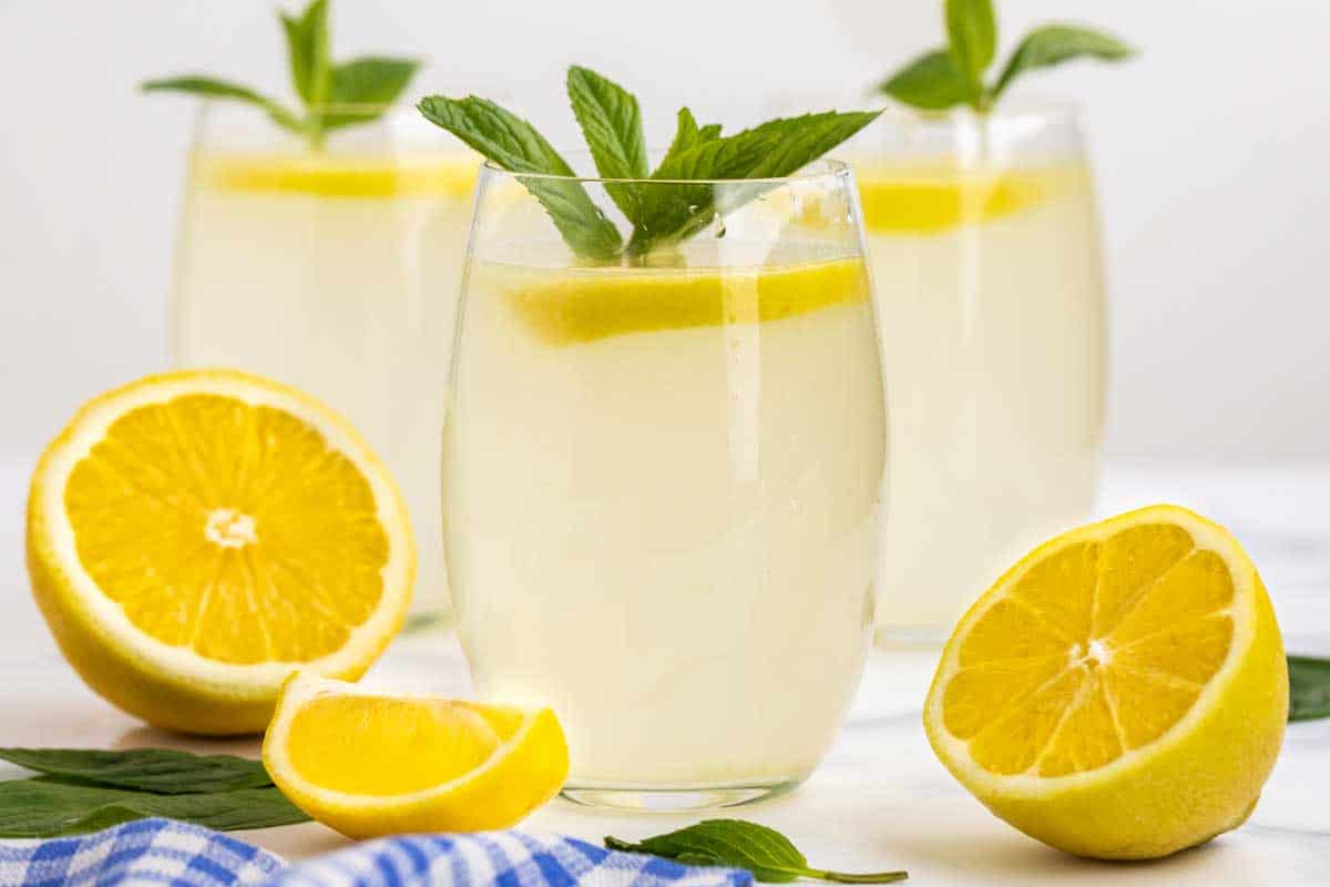 Glasses of lemonade with fresh lemon slices and mint garnish.