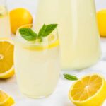 Glass of lemonade with fresh lemon slices and mint garnish.