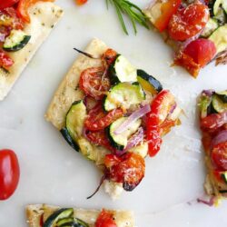 Slices of flat bread topped with summer roasted vegetables.