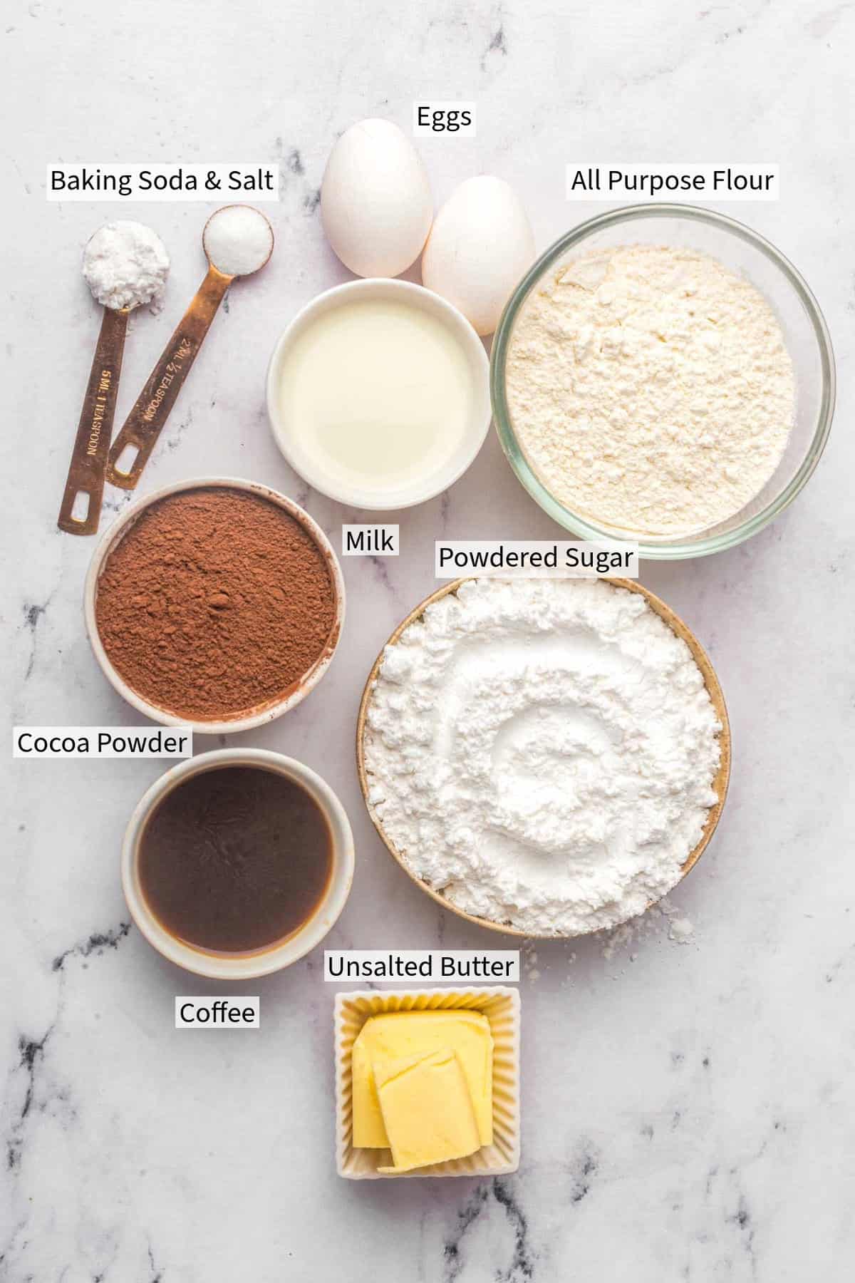 Ingredients for a Matilda Chocolate Cake: eggs, all-purpose flour, baking soda and salt, milk, powdered sugar, cocoa powder, coffee, and unsalted butter.